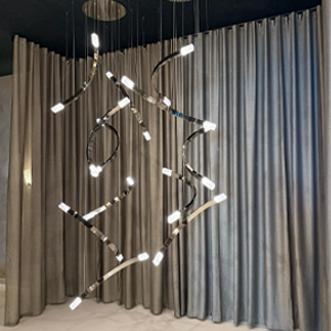 A close-up of elegantly curved brass lighting components, precision-bent by Barnshaws for CTO Lighting. 